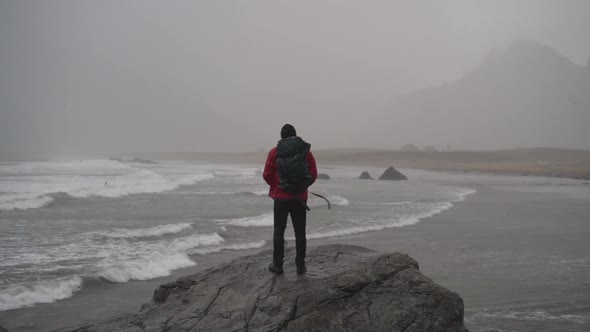 Hiker Standing On Rock Watching Surfer