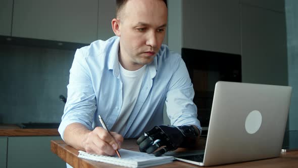 Skilled company manager cyborg guy with bio hand prothesis looks at laptop display