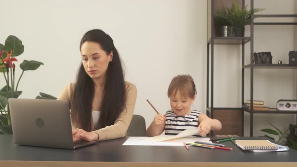 Mother Trying to Work From Home with Little Daughter