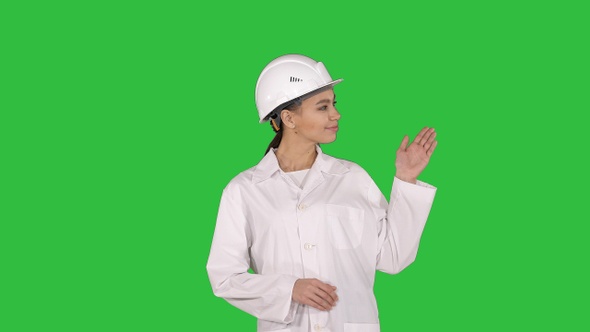 Mature engineer woman in hard hat indicating to the product