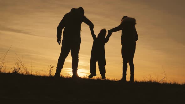 Silhouette Happy Child with Mother and Father Family at Sunset