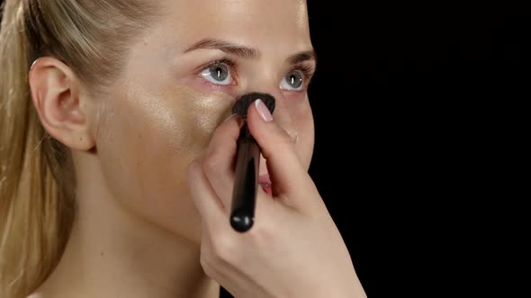 Makeup. Applying Foundation. Black. Closeup