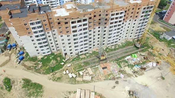 Building construction of the modern residential complex with two cranes near the multy-storey