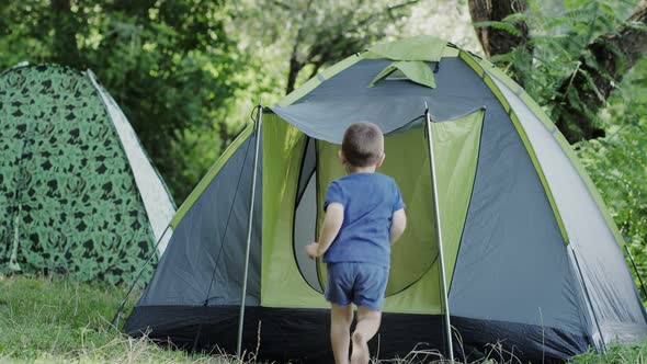 Family mom and son playing together near tent. Happy childhood and motherhood.