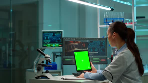 Microbiologist Working on Notepad with Green Chroma Key Display