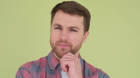 Close Up of a Man with Blue Eyes on a Yellowgreen Background He Looks Intently Straight