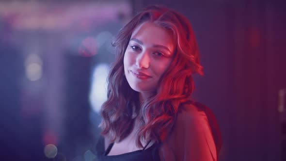 Glamour Female in Nightclub Young Female Smiling and Looks at the Camera Neon Light