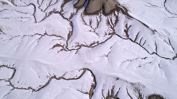 Aerial view looking at textured desert terrain in the snow