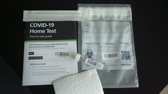 Covid-19 Coronavirus home test kit with guide, test tube and cotton q tip on the table