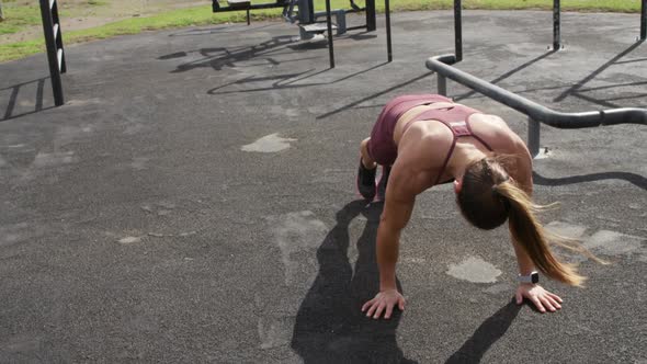 Sporty Caucasian woman exercising in an outdoor gym during daytime