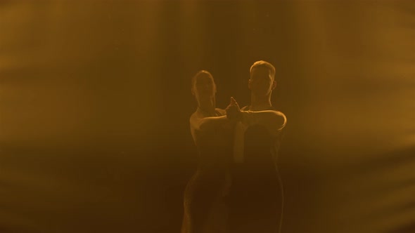 Silhouettes of a Pair of Dancers Performing Elements of Argentine Dance Appear Against the Smoky