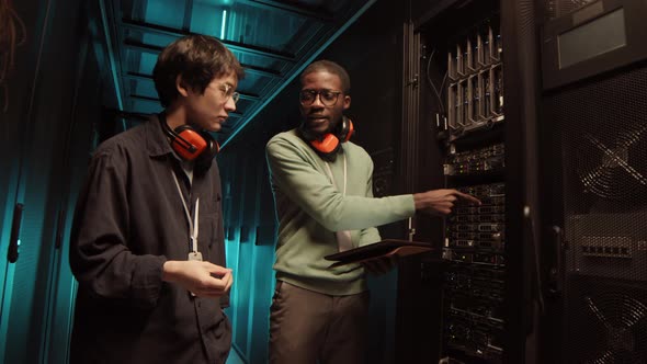 Two IT Engineers Having Conversation in Data Center