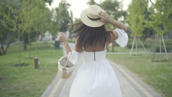 Gorgeous Slim Middle Eastern Woman White Dress Straw Hat Spinning As Strolling Along Sunny Summer