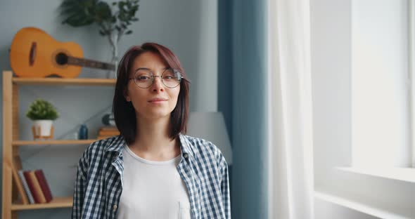 Portrait of Young Lady in Glasses Turning To Camera Smiling Looking at Camera