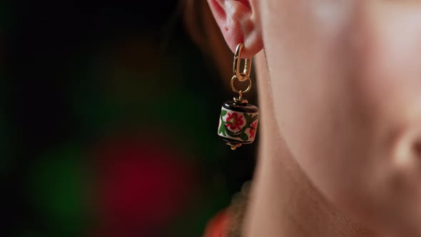 Ukrainian Woman with Craft Ceramics Earrings Posing on Dark Colorful Background