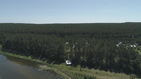 Aerial view of wedding arch on the pier by the river next to the forest 03