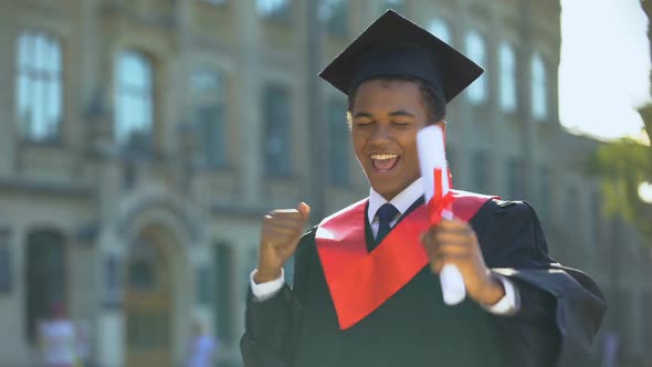 Cheerful Male Dancing Celebrating Graduation Outdoors University, Knowledge