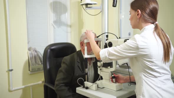 Ophthalmologist Examination of Elderly Man with Slit Lamp