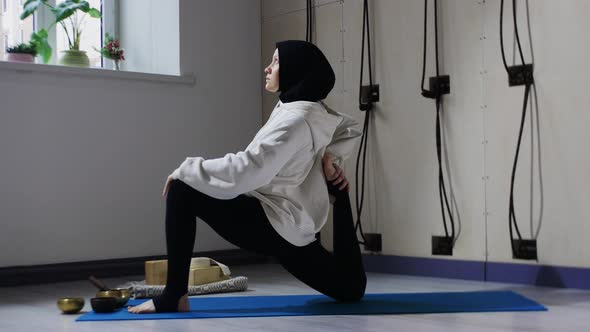 A Woman in Hijab Doing Yoga Exercises on Yoga Mat