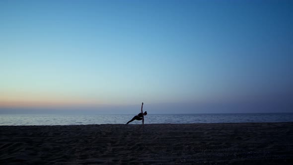 Silhouette Yoga Woman Training Warrior Asana in Front Beautiful Sunset Sky