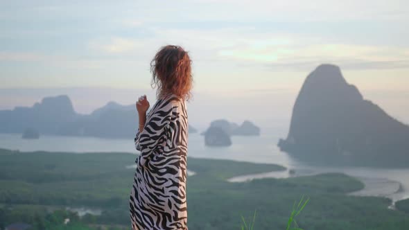 Woman Enjoys Sunset on Mountain Pick She Looks From the Top To Amazing Bay