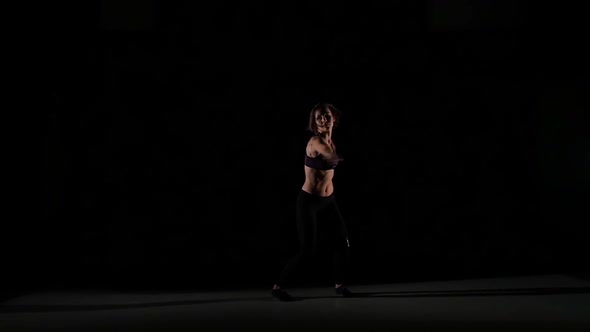 Dancer Girl Moves Contemporary with Unusual Tricks in the Shadow on Black Background, Slow Motion