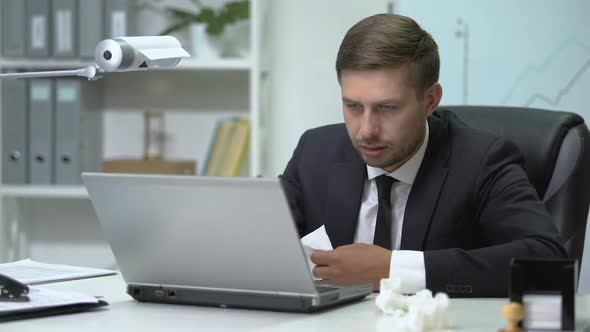 Ill Businessperson Sneezing in Tissue During Working on Laptop in Office, Flu