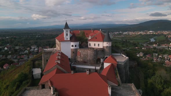 Aerial View of Medieval Castle on Mountain in Small European City at Cloudy Autumn Day