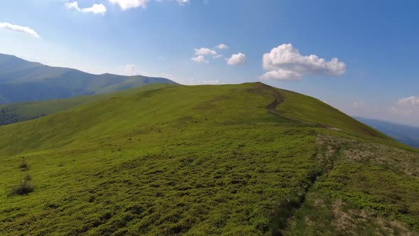 Aerial flight over green hill mountains. FPV Dynamic drone shot