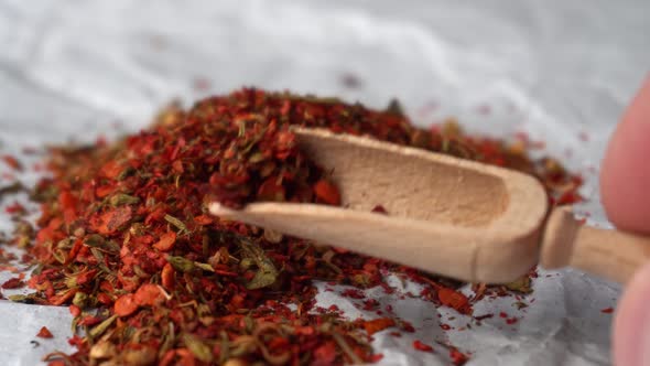 Heap of Fresh Red Aromatic Spices Mixing with Wooden Spoon on White Papper