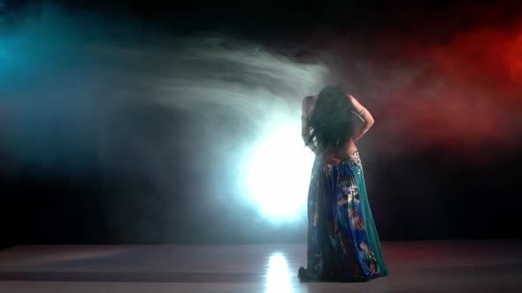 Belly Dancer in a Blue Stage Costume Dancing in Smoke, on Red, Blue, Slow Motion