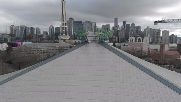 Aerial shot pushing towards the Climate Pledge Arena sign with Seattle Center in the background.