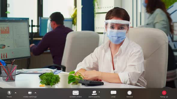 Businesswoman with Visor and Mask Talking in Front of Camera