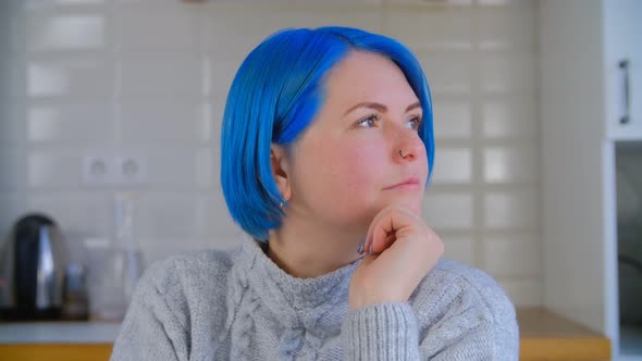 Millenial girl with colored blue hair thinking about solution in closeup 4k video clip