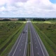 Cars Drive Along Highway with Two Lanes Across Green Meadow - VideoHive Item for Sale