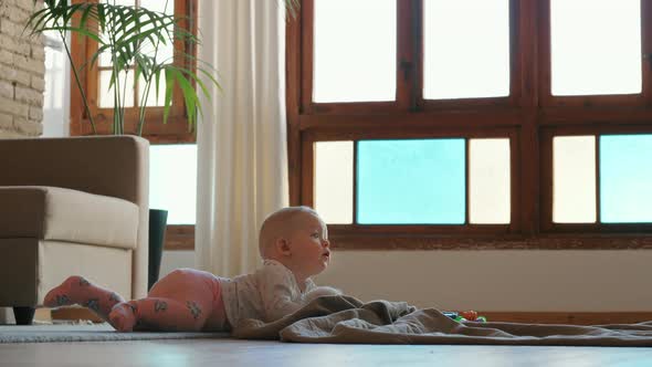 Baby Girl Lying on the Floor and Playing