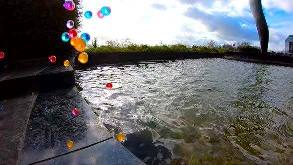 Colorful bouncing balls at the edge of the fountain.