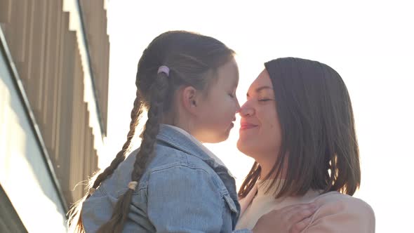 Young Woman Lovingly Hugs a Girl with Pigtails 67 Years Old