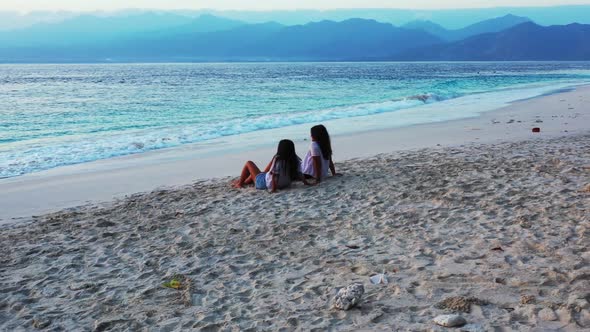 Beautiful ladies relaxing on relaxing tourist beach holiday by clear sea with white sand background 
