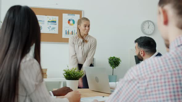 Happy Business Lady Speaking to Group of Colleagues Then Dancing Celebrating Successful Work