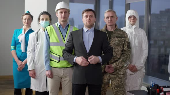 Handsome Confident Caucasian Businessman Standing with Group of People of Different Professions