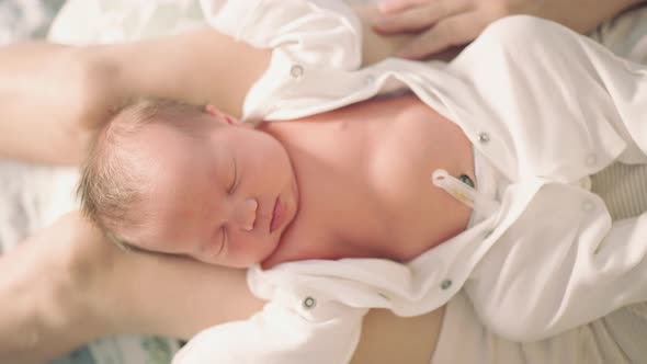 top view newborn baby lies on mother's lap alt