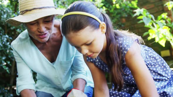 Grandmother and grand daughter planting plants