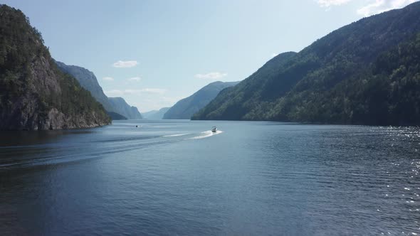 Aerial shot following a speedboat through Mesmerizing Norwegian fjord Scene
