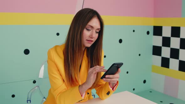 Woman In Yellow Jacket Uses Gadget