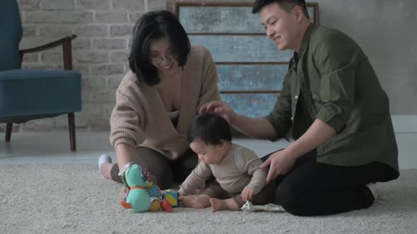 happy family mother father in living room playing with little newborn son.