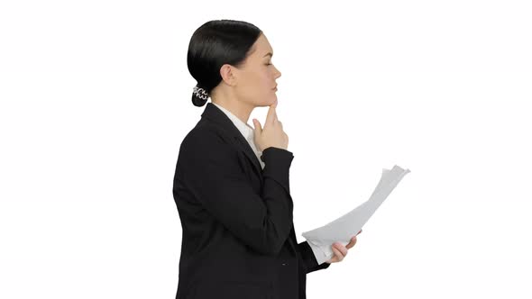 Serious Businesswoman Reading Report Preparing for a Presentation While Walking on White Background