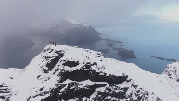 Drone Over Hikers On Mountain Summit In Snow