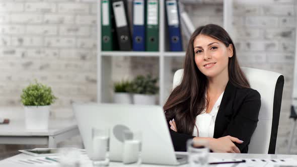 Smiling Caucasian Stylish Businesswoman Posing at Workplace Looking at Camera Medium Shot
