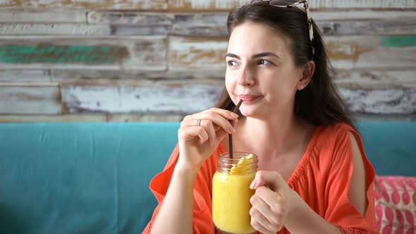 Young Petty Woman Drinking Fresh Tropical Mango Smoothie Shake